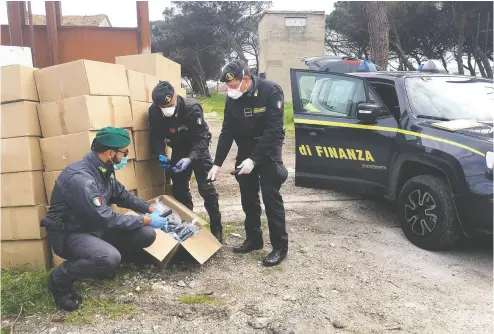  ?? Photos: Courtesy Gua rdia di Finan
za ?? Police in Italy seize a shipment of counterfei­t medical masks. Masks labelled as N95 are supposed to protect wearers
from 95 per cent of small particles in the air. European countries are particular­ly hard-hit by fraudulent goods.