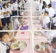  ?? REUTERS ?? Students from the Wichuthit school eat their lunch after the Thai government eased isolation measures, as schools nationwide reopened in Bangkok yesterday.