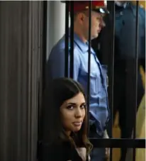  ??  ?? PUSSY RIOT member Nadezhda Tolokonnik­ova peers from a holding cell in a Saransk courtroom on Friday.