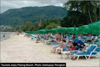  ?? Photo: Eakkapop Thongtub ?? Tourists enjoy Patong Beach.