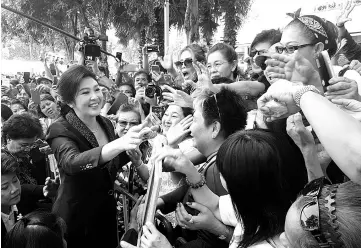  ??  ?? Yingluck greeting supporters as she leaves the Supreme Court in Bangkok,Thailand. — Reuters photo