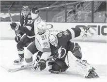  ??  ?? The Florida Panthers’ Anthony Duclair, 91, collides with Tampa Bay Lightning goaltender McElhinney as Ryan McDonagh defends during the first period Monday.