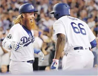 ??  ?? Dodgers slugger Justin Turner, left, celebrates his two-run homer with teammate Yasiel Puig during the sixth inning of Game 1 in Los Angeles on Tuesday.