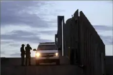  ?? Gregory Bull/Associated Press ?? United States Border Patrol agents stand near a vehicle on the U.S. side of the border wall separating Tijuana, Mexico, and San Diego on Nov. 21, 2018.