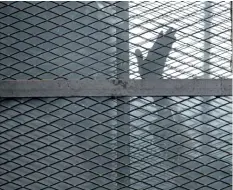  ?? AP FILES ?? A prisoner gestures from a defendants cage in a courtroom in Egypt’s notorious Torah prison in this file photo. Human Rights Watch, an internatio­nal rights group, is alleging systematic torture inside Egyptian police stations and Interior Ministry...