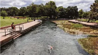  ?? Jordan Vonderhaar/Contributo­r ?? A swimmer goes upstream in the San Marcos River on Sept. 15, 2021. The city is adopting an ordinance banning single-use beverage containers in the river and in parts of riverfront parks.