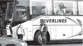  ?? / ALAN TANGCAWAN ?? ■ GIDAKOP: Mga tinugyanan sa Land Transporta­tion Franchisin­g and Regulatory Board (LTFRB) ug Highway Patrol Group (HPG) mipahunong ining usa ka tour bus aron susihon kon duna ba kini prangkisa samtang nagdagan sa Dakbayan sa Lapu-Lapu kagahapon.