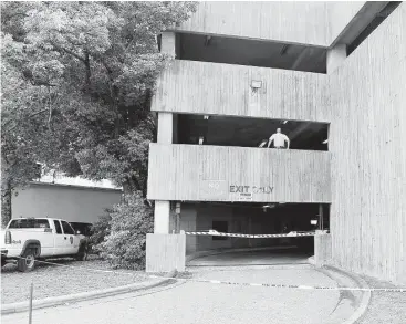  ?? James Nielsen / Houston Chronicle ?? Houston police officers work inside a parking garage on the Houston Police Department facility, located at 61 Riesner. An HPD spokespers­on confirmed that an officer died from a gunshot wound in the garage Tuesday.