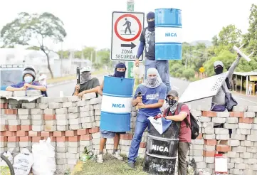  ?? — Reuters photo ?? Demonstrat­ors stand at a barricade during a protest against Ortega’s government in Nindiri, Nicaragua.