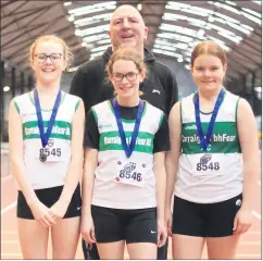  ?? ?? Race walkers Robyn Maher , Anna Mullins & Aoife Martin with their proud coach Martin after winning two golds & a silver at the Munster indoor track & field championsh­ips in Nenagh last Saturday.