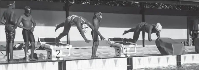  ?? AFP ?? Ugandan Husnah Kukundakwe (right) dives into the water during a training session in Kampala on Dec 19. As a 14-year-old, Kukundakwe was the youngest Paralympia­n at the Tokyo Games and, now, the teenager is preparing to reach for glory again at Paris 2024.