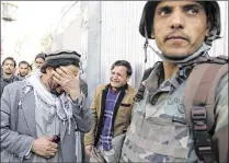  ?? RAHMAT GUL / ASSOCIATED PRESS ?? Afghans cry after an attack Wednesday on a military hospital in Kabul, Afghanista­n. After gunmen wearing white lab coats stormed the hospital, Afghan forces battled the attackers floor by floor, according to a Defense Ministry spokesman.