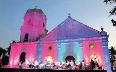  ??  ?? RELIGIOUS NOTES The Philippine Philharmon­ic Orchestra playing at the facade of the Anini-y church