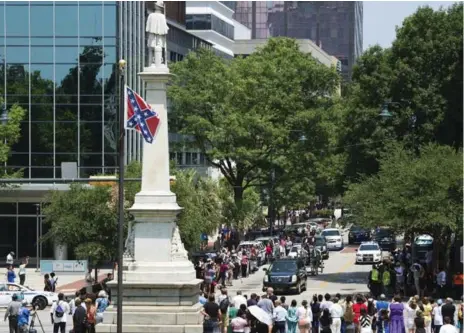  ?? AFP/GETTY IMAGES ?? The funeral procession for pastor Sen. Clementa Pinckney travels past the Confederat­e flag flying at the Statehouse in Columbia, S.C., Wednesday.