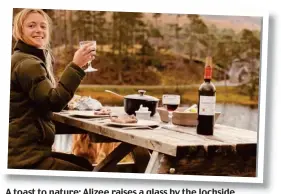  ??  ?? A toast to nature: Alizee raises a glass by the lochside