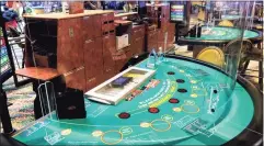  ?? Joe Amarante / Hearst Connecticu­t Media ?? Plexiglass wraps around a blackjack table at Mohegan Sun in a preview of the casino’s return in late spring.