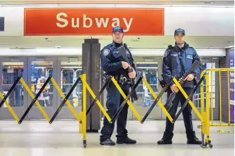  ?? ANDRES KUDACKI/ASSOCIATED PRESS ?? Police stand guard inside the Port Authority Bus Terminal following an explosion near Times Square in New York on Monday. They said a man with a pipe bomb strapped to his body set off the crude device.