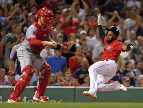  ?? STUART CAHILL / BOSTON HERALD ?? ON A GOOD RUN: Jackie Bradley Jr. slides into home on Rafael Devers’ single in the sixth inning last night at Fenway as Angels catcher Max Stassi waits for the throw. The Red Sox rolled to a 16-4 victory.