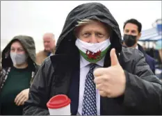  ?? WOOD/PA VIA AP
MATTHEW HOR- ?? Britain’s Prime Minister Boris Johnson wears a Welsh flag face mask during a visit to Barry Island, Wales, as part of the Welsh Conservati­ve Party’s Senedd election campaign, Monday.