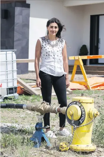  ?? LIAM RICHARDS ?? “All these hoses and all this dirt, it drives me crazy. But I try not to think about it too much,” says Aspen Ridge homeowner Susan Serrano of the temporary water lines in the neighbourh­ood.