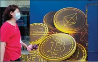  ?? ?? A woman walks past an advertisem­ent for the Bitcoin cryptocurr­ency in Hong Kong. Bitcoin once again slipped below $17,000 on Saturday to an intraday low of $16,543.48, less than 24 hours after residing at a high of $17,480.18, as it was reported that a hack on FTX had taken place. — ap