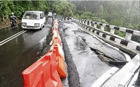  ??  ?? Risky route: Motorists seen driving along Jalan Bukit Lama leading to Bayan Lepas which collapsed due to the downpour in Balik Pulau, Penang.