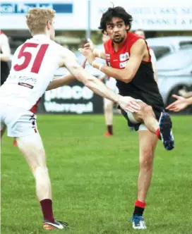  ??  ?? One of Warragul’s best in the reserves’ match on Saturday Rowan Lawson-Pepper gets his kick away ahead of a late smothering attempt by Traralgon opponent Ben Cheetham.