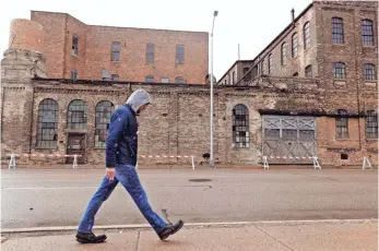  ?? PHOTOS BY RICK WOOD/MILWAUKEE JOURNAL SENTINEL ?? Stephen Stansbury, who lives in Racine’s urban center, walks past the former Gold Medal Camp Furniture Manufactur­ing Co., which was sold in 1989. Once a titan of Midwest manufactur­ing, the city’s economy has defied decades of jobs programs, wars on...