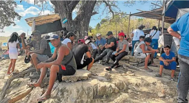  ?? // AFP ?? Varios familiares esperan para recibir los cuerpos de los mineros fallecidos tras el derrumbe de una mina ilegal en Puerto Guacara, en La Paragua