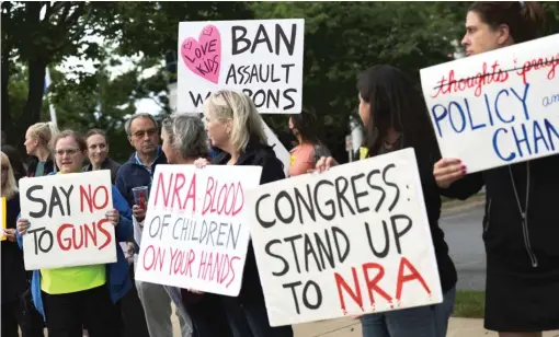  ?? KEVIN DIETSCH/GETTY IMAGES ?? Gun-restrictio­n advocates hold a vigil outside of the National Rifle Associatio­n headquarte­rs in Fairfax, Virginia, following the recent mass shooting at Robb Elementary School in Uvalde, Texas.