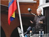  ?? Associated Press ?? WikiLeaks founder Julian Assange gestures Friday as he speaks on the balcony of the Ecuadorian embassy in London. Assange has won his battle against extraditio­n to Sweden, which wanted to question him about a rape allegation.