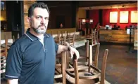  ?? Sue Ogrocki/Associated Press ?? ■ JJ Kuhn, general manager of Yucatan Taco Stand Tequilla Bar and Grill, poses for a photo in the empty dining room at the restaurant on March 27 in Oklahoma City. The Women’s College World Series, canceled because of the COVID-19 outbreak, has been hosted in Oklahoma City every year except one since 1990.