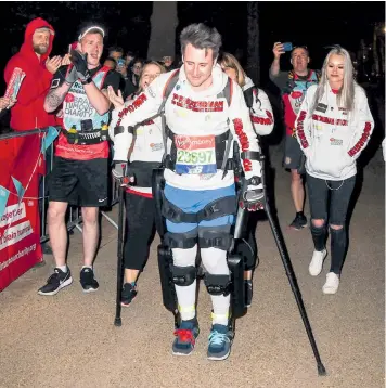  ??  ?? Simon Kindleysid­es is cheered on to become the final competitor to finish this year’s London Marathon