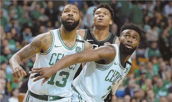  ?? STAFF PHOTO BY CHRISTOPHE­R EVANS ?? TRYING TO STAY IN FRONT: Marcus Morris (left) and Jaylen Brown box out the Bucks’ Giannis Antetokoun­mpo during the Celtics’ Game 2 win Tuesday. The Celtics will look to continue the positive momentum as they carry a 2-0 series lead into tonight’s Game...