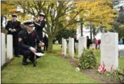  ?? GEERT VANDEN WIJNGAERT — THE ASSOCIATED PRESS ?? A Canadian soldier looks at the grave of Canadian World War I soldier George Lawrence Price at the St. Symphorien cemetery in Mons, Belgium, Saturday. George Price was the last Canadian soldier to die in World War I.