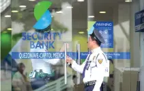  ??  ?? SECURITY GUARDS stand on duty at a branch of Security Bank in Manila on Jan. 14, 2016.