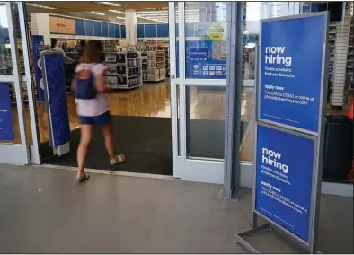  ?? (AP/Marta Lavandier) ?? A “now-hiring” sign sits Tuesday at the entrance to a Bed, Bath and Beyond store in Miami. The number of Americans seeking unemployme­nt aid fell last week to the lowest since the pandemic began 14 months ago.