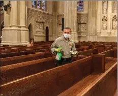  ?? (The New York Times/September Dawn Bottoms) ?? A worker cleans the pews at St. Patrick’s Cathedral in Manhattan. Monsignor Robert Ritchie, the cathedral’s rector, said St. Patrick’s is struggling financiall­y without donations from the thousands who turn out each week for Sunday Mass, and the more than five million tourists who come through the building each year.