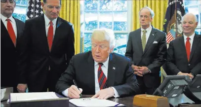  ?? Manuel Balce Ceneta ?? The Associated Press President Donald Trump signs the America’s Water Infrastruc­ture Act into law during a ceremony Tuesday in the Oval Office.