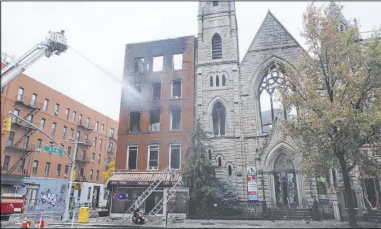  ?? Yuki Iwamura The Associated Press ?? Firefighte­rs work to extinguish the blaze that erupted Saturday from a building next to the Middle Collegiate Church in New York.