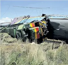  ?? THE ASSOCIATED PRESS ?? Ruined train cars are seen at the scene of a train accident near Kroonstad, South Africa, on Thursday. At least 12 people died and 268 were injured when a truck driver tried to cross the tracks in front of the train.