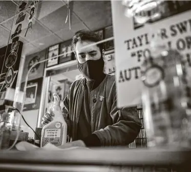  ?? Marie D. De Jesús / Staff photograph­er ?? Steven Suarez, 33, disinfects his work space at Cactus Music in Houston. Suarez lost his job at Academy after a disagreeme­nt with a customer who said he had asthma and couldn’t wear a mask.