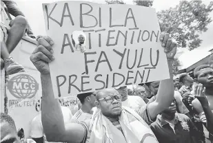  ?? — Gambar Reuters ?? SOKONGAN PADU: Penyokong Fayulu membawa poster sebelum perhimpuna­n politik berlangsun­g di Kinshasa, Congo, pada 11 Januari lepas.