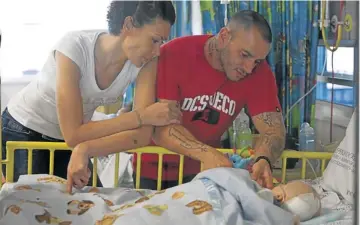  ?? Picture: HALDEN KROG ?? ‘LIVING EACH DAY AS IT COMES’: The parents of Sergio Amaro De Sousa, Mario and Leigh, stand by the bedside of their son after his 23rd operation in 10 months at the Red Cross War Memorial Children’s Hospital in Cape Town
