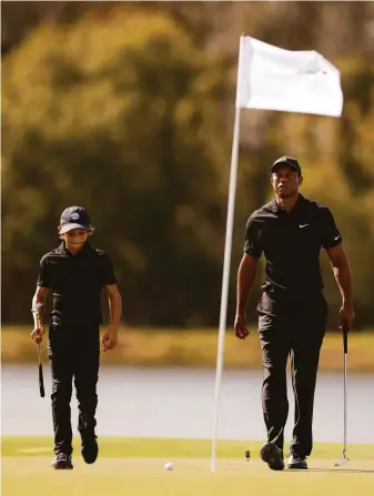  ?? Douglas P. DeFelice / Getty Images ?? Ten months after surviving an auto accident, Tiger Woods walks the course with his son Charlie during the pro-am event ahead of the weekend’s PNC Championsh­ip in Orlando.