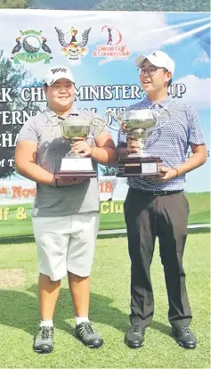  ??  ?? Mirabel and Malcolm with their champion trophies at the 20th Sarawak Internatio­nal Junior Golf Championsh­ip 2018.