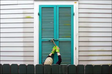  ?? CHRIS GRANGER — THE TIMES-PICAYUNE — THE NEW ORLEANS ADVOCATE VIA AP ?? Storm shutters are hammered closed on a 100-year-old house, Friday, August 27, in New Orleans, as residents prepare for Hurricane Ida.