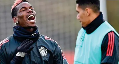  ?? AFP ?? Laughter is the best medicine: Pogba looks over his illness in training with Smalling yesterday