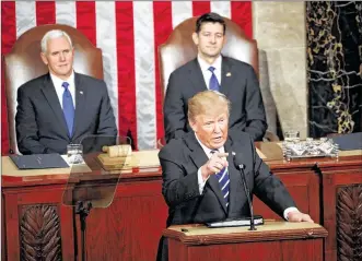  ?? DOUG MILLS/THE NEW YORK TIMES ?? President Donald Trump, backed by Vice President Mike Pence and House Speaker Paul Ryan (R-Wis.), speaks to a joint session of Congress on Tuesday in Washington.