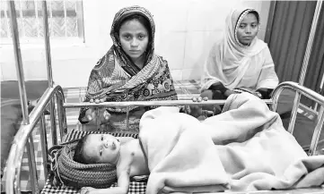  ??  ?? File photo shows a Rohingya mother (left) sitting next to her sick child, who is treated at a Doctors Without Borders (MSF) clinic, at Kutupalong refugee camp in Bangladesh’s Ukhia district. — AFP photo